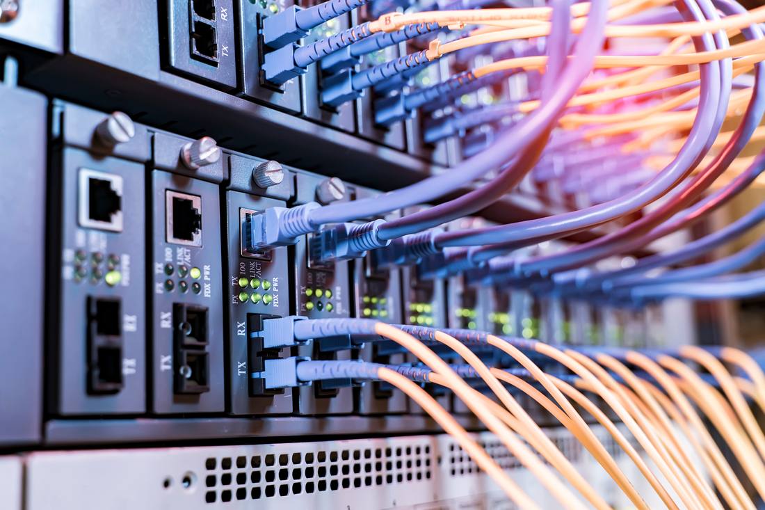 Netzwerk- und Glasfaserkabel an einem Switch im Serverschrank